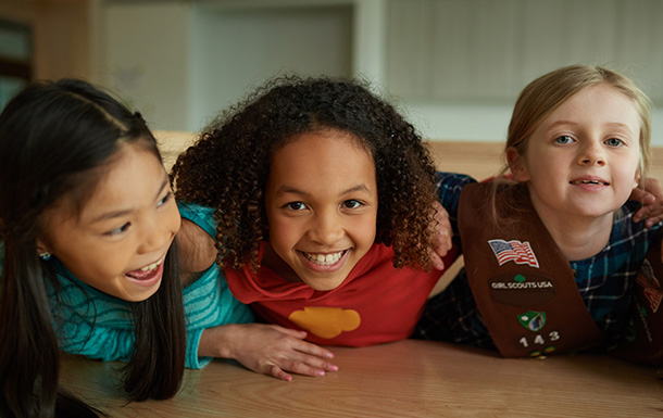 Three Girl Scout Brownies with their arms around each other