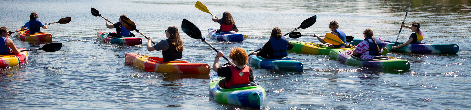  two girls kayaking across a lake 