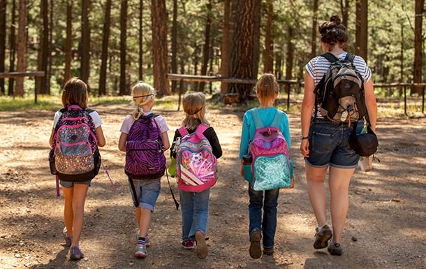 four girls and volunteer wearing backpacks